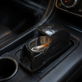 Car ashtray with a lit cigarette inside on a car dashboard